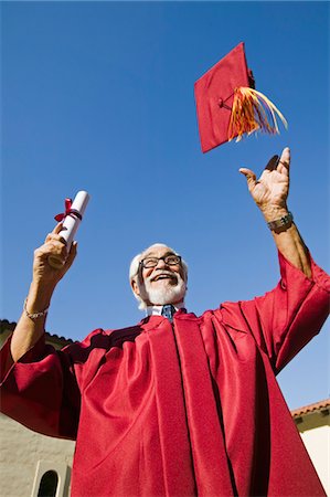 simsearch:693-06014222,k - Senior graduate tossing hat in air outside, low angle view Stock Photo - Premium Royalty-Free, Code: 693-06014228