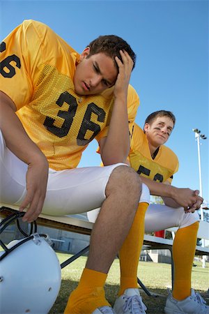 Two football players sitting on bench, low angle view Fotografie stock - Premium Royalty-Free, Codice: 693-06014422