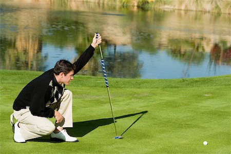 Golfer lining up putt Stock Photo - Premium Royalty-Free, Code: 693-06014467