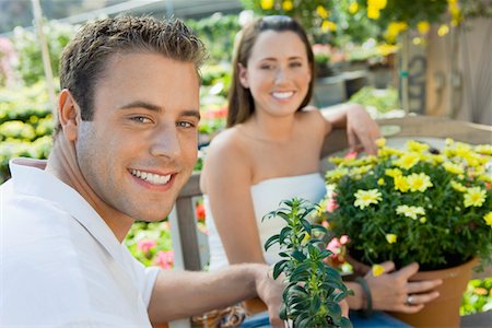 flower decision images stage - Young couple sitting on bench in garden centre, (portrait) Stock Photo - Premium Royalty-Free, Code: 693-06014518