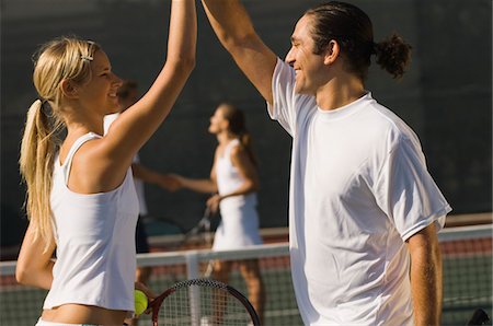Mixed Doubles Partners High-Fiving Each Other on tennis court, side view Foto de stock - Sin royalties Premium, Código: 693-06014672