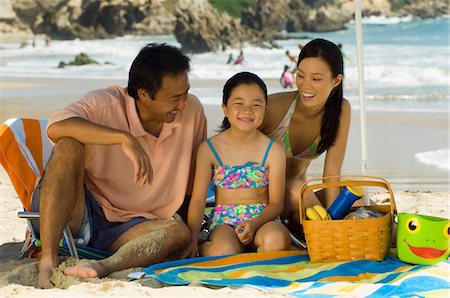 Parents with daughter (7-9) having picnic on beach Stock Photo - Premium Royalty-Free, Code: 693-06014719