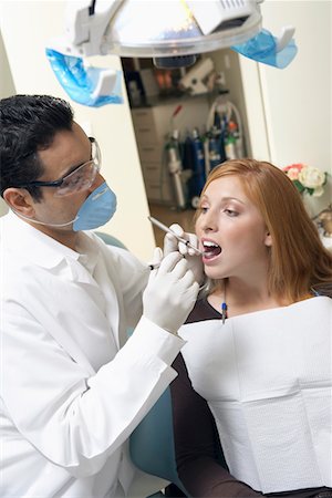 female with dental tools at work - Dentist examining young womans teeth in surgery Stock Photo - Premium Royalty-Free, Code: 693-06014934