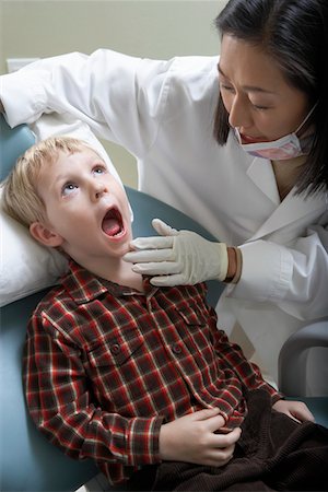 Female dentist examining boy (6-9) in surgery Stock Photo - Premium Royalty-Free, Code: 693-06014949