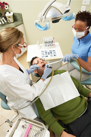 dental pictures black & white - Dentists examining male patient in surgery Stock Photo - Premium Royalty-Free, Code: 693-06014957