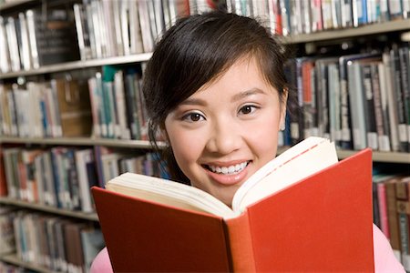 excited college student with books - Young woman reading at library Stock Photo - Premium Royalty-Free, Code: 693-06014975