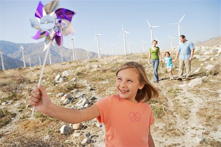 pin wheel family - Girl (7-9) with pinwheel standing on wind farm, portrait Stock Photo - Premium Royalty-Free, Code: 693-06015041