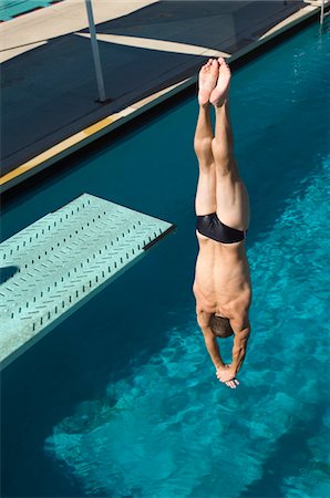 Young man diving into swimming pool Stock Photo - Premium Royalty-Free, Code: 693-06015098