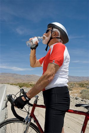 Senior man with bike drinking water Stock Photo - Premium Royalty-Free, Code: 693-06015387