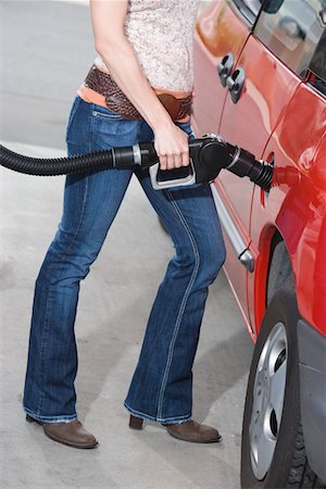 Woman by car with fuel pump Stock Photo - Premium Royalty-Free, Code: 693-06015527