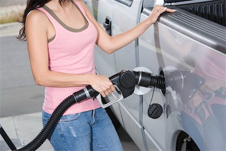 Woman by car with fuel pump, mid section Stock Photo - Premium Royalty-Free, Code: 693-06015532