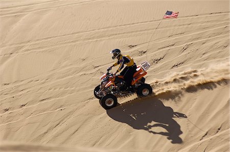 quad biking - Young Man Riding ATV Over Sand Dune Stock Photo - Premium Royalty-Free, Code: 693-06015645
