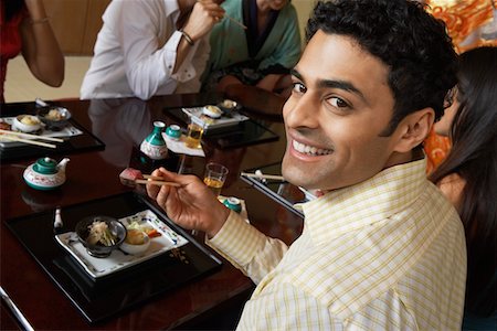 fish restaurant - Young people eating sushi with chopsticks in restaurant, elevated view Stock Photo - Premium Royalty-Free, Code: 693-06015656