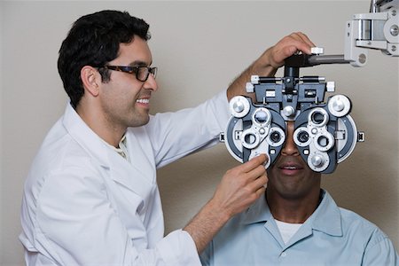 Optometrist examining patient's eyes Foto de stock - Sin royalties Premium, Código: 693-06015871