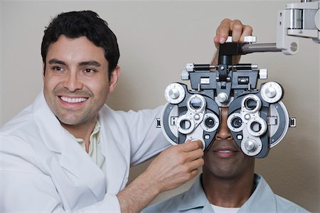 Optometrist examining patient's eyes Foto de stock - Sin royalties Premium, Código: 693-06015872