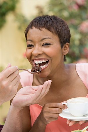 Woman sharing dessert outdoors Stock Photo - Premium Royalty-Free, Code: 693-06015957