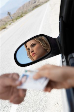 drivers licence - Woman sitting in car handing diving licence to police officer Stock Photo - Premium Royalty-Free, Code: 693-06016083