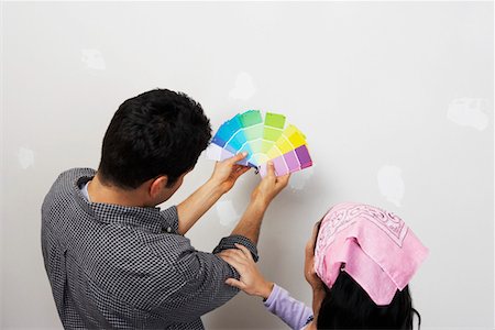 Couple looking at paint samples near interior wall, back view, elevated view Stock Photo - Premium Royalty-Free, Code: 693-06016106