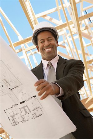 simsearch:693-06016692,k - Smiling Surveyor in hard hat with building plans on Construction Site, low angle view Stock Photo - Premium Royalty-Free, Code: 693-06016699