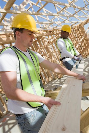 Two construction workers measuring wooden plank Stock Photo - Premium Royalty-Free, Code: 693-06016744