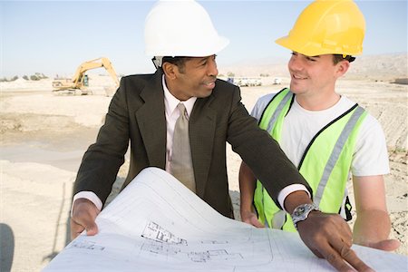 Surveyor and construction worker studying blueprint Stock Photo - Premium Royalty-Free, Code: 693-06016794
