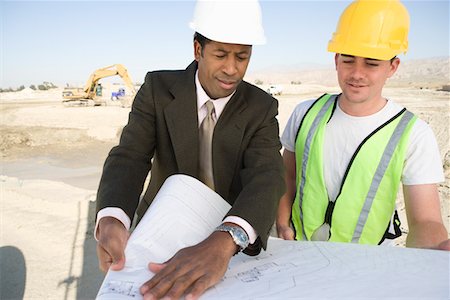 Surveyor and construction worker studying blueprint Stock Photo - Premium Royalty-Free, Code: 693-06016795
