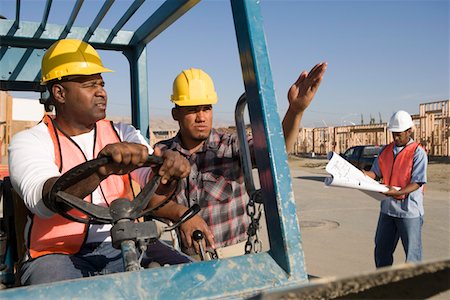 Construction worker showing direction to another worker steering vehicle Stock Photo - Premium Royalty-Free, Code: 693-06016869