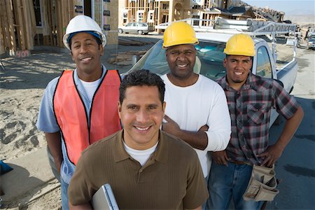 Four construction workers standing in front of car on construction site Stock Photo - Premium Royalty-Free, Code: 693-06016863