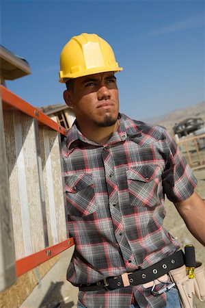 Construction worker carrying step ladder on construction site Foto de stock - Sin royalties Premium, Código: 693-06016893