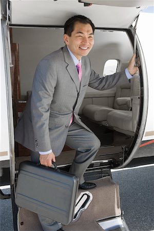 Asian businessman getting off airplane. Stock Photo - Premium Royalty-Free, Code: 693-06016959
