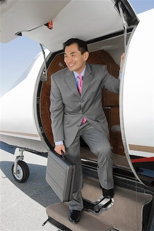 Asian businessman getting off airplane. Stock Photo - Premium Royalty-Free, Code: 693-06016964