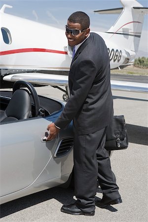 African-American businessman opening door of convertible on landing strip. Foto de stock - Sin royalties Premium, Código: 693-06016973