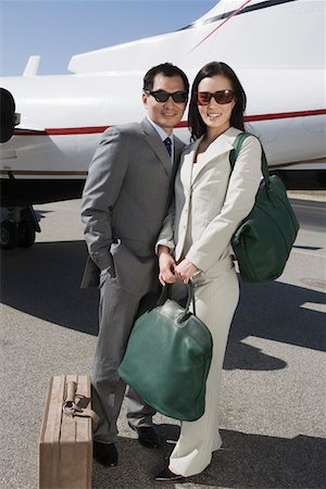 Portrait of mid-adult Asian business couple standing outside of private airplane. Stock Photo - Premium Royalty-Free, Code: 693-06016994