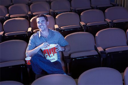 simsearch:693-03707208,k - Homme assis seul dans le théâtre vide manger le pop-corn, regarder film Photographie de stock - Premium Libres de Droits, Code: 693-06017218