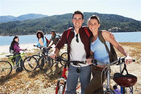 Young people standing with mountain bikes in front of lake Stock Photo - Premium Royalty-Free, Code: 693-06017490