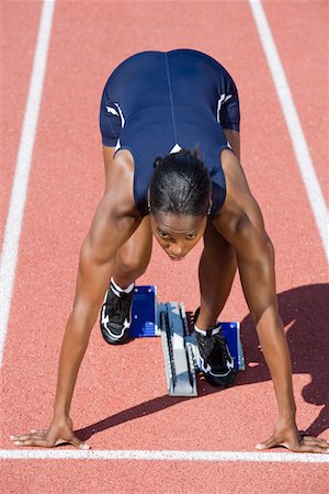 starting block kneeling race track - Female athlete in starting block, ready to run Stock Photo - Premium Royalty-Free, Code: 693-06017770