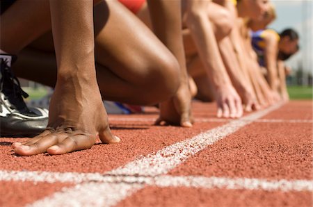 Group of female track athletes on starting blocks Stock Photo - Premium Royalty-Free, Code: 693-06017862