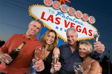 simsearch:693-06018149,k - Two women and two men posing in front of Welcome to Las Vegas sign, group portrait. Stock Photo - Premium Royalty-Free, Code: 693-06018087