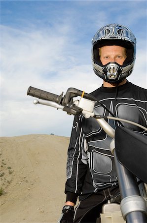 Motocross racer on bike in desert, (portrait) Stock Photo - Premium Royalty-Free, Code: 693-06018243