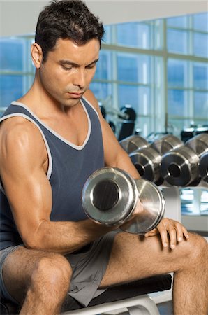 simsearch:632-05991605,k - Man using dumbbell in gymnasium Foto de stock - Royalty Free Premium, Número: 693-06018257