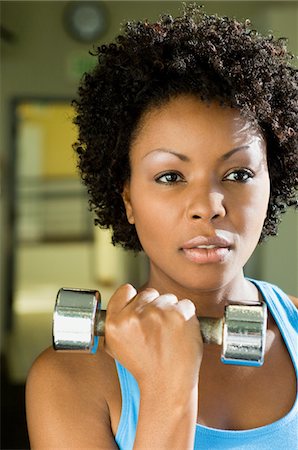 Woman using dumbbell indoors, (close-up), (portrait) Stock Photo - Premium Royalty-Free, Code: 693-06018260