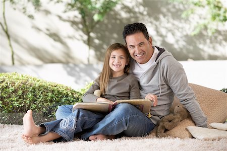 Father and daughter reading on floor, portrait Stock Photo - Premium Royalty-Free, Code: 693-06018469