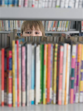 simsearch:649-06812246,k - Boy peeking from behind bookshelf in library Stock Photo - Premium Royalty-Free, Code: 693-06018506