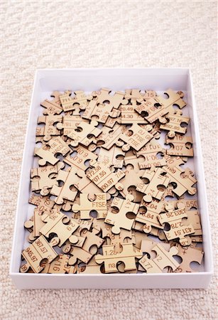 peça perdida - Jigsaw puzzle pieces in box, elevated view Foto de stock - Royalty Free Premium, Número: 693-06018699