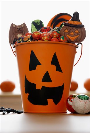 Bucket with Jack O'lantern face filled with sweets in studio Stock Photo - Premium Royalty-Free, Code: 693-06018954