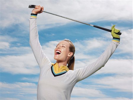 simsearch:693-06016661,k - Happy female golfer holding club against sky Stock Photo - Premium Royalty-Free, Code: 693-06019127