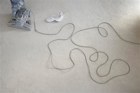 Cord, vacuum cleaner and shoes laying on carpet Stock Photo - Premium Royalty-Free, Code: 693-06019123