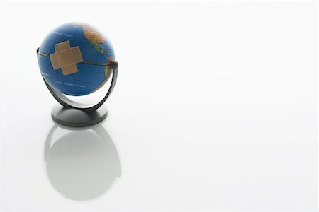 Globe with two pieces of sticking plaster on it Fotografie stock - Premium Royalty-Free, Codice: 693-06019231