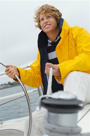 simsearch:693-06019372,k - Young man standing at yacht helm Stock Photo - Premium Royalty-Free, Code: 693-06019388