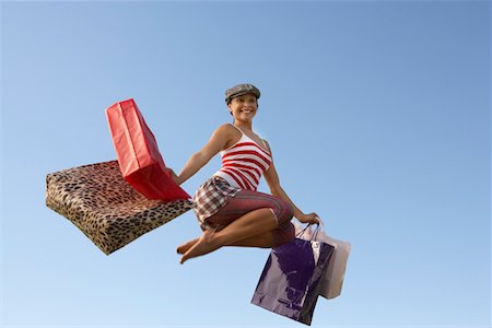 Portrait of young woman jumping with shopping bags Stock Photo - Premium Royalty-Free, Code: 693-06019417